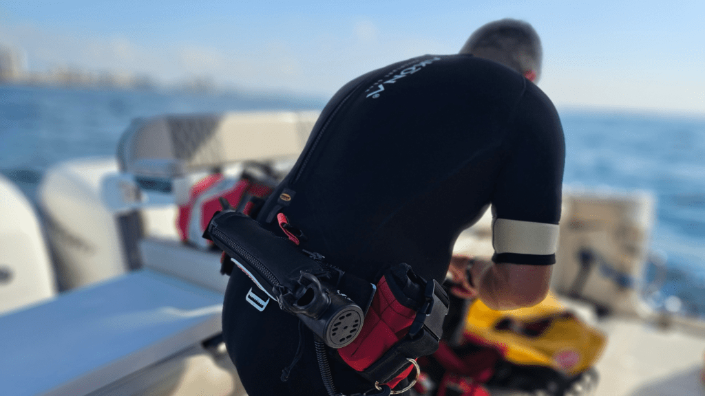 Diver preparing his belt with Spare Air and weights on a boat.